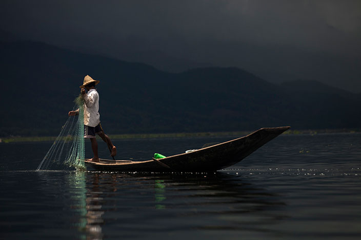 Cover-More New Zealand Facebook photo competition winner: Fisherman rowing out his net on Inle Lake after a rain shower