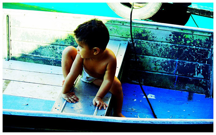 Cover-More New Zealand Facebook photo competition winner: A toddler climbing in a boat in the Amazon Jungle in Brazil