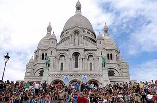 Crowds gather on the steps of Sacre Coeur to look over the landscape of Paris from the highest point in the city.