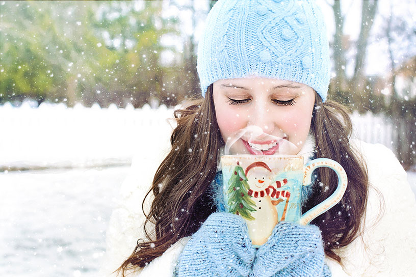 woman drinking hot chocolate in finland out in snow